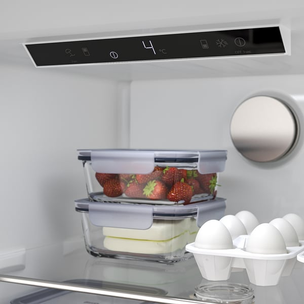 In einem modernen Kühlschrank werden Erdbeeren und Käse ordentlich in Behältern aufbewahrt. Die Digitalanzeige des Kühlschranks zeigt die Temperatur bei 4°C an.