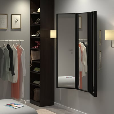 Schwarzer dreifach gefalteter Spiegel im Schrank, reflektiert den Raum, ideal für Outfits.