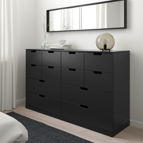 Minimalistisches Schlafzimmer: NORDLI schwarze Kommode mit 9 Schubladen, Spiegel oben, Lampe und Dekor oben. Passt unter ein großes Fenster.