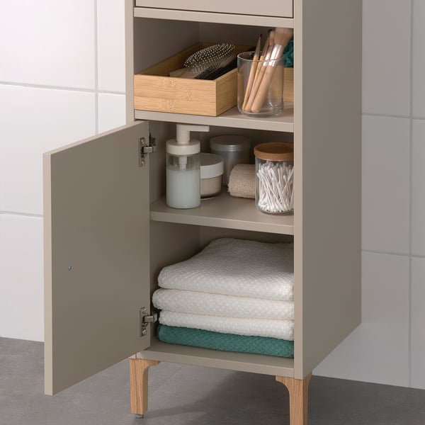 Schrank mit offenem und verstecktem Stauraum, ideal für kleine Räume. In den Regalen befinden sich Handtücher und Badutensilien.