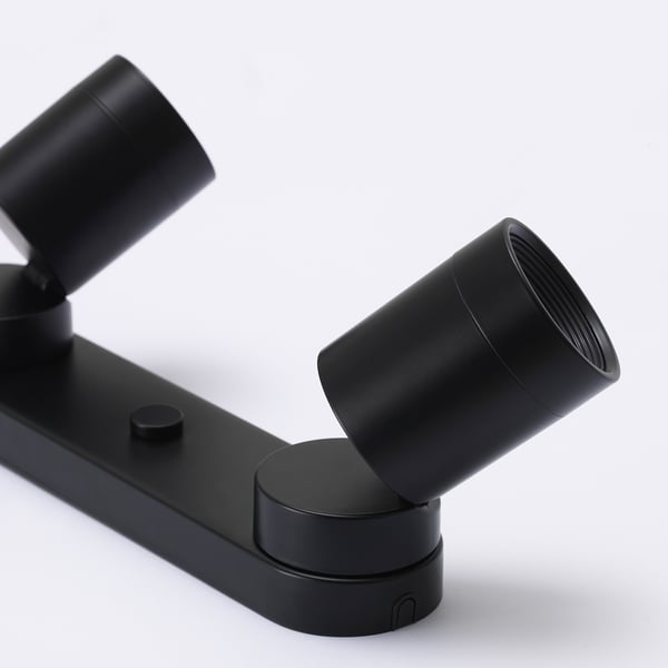 Schwarze, moderne, verstellbare Strahlerleuchte mit schlanken, zylindrischen Lampen.
