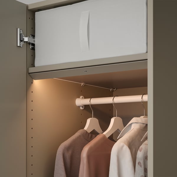 Schrank mit eingebautem LED-Licht, Kleiderbügeln und Kleidung.