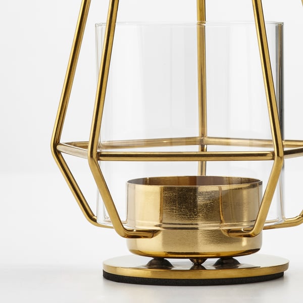 Kerzenhalter aus goldfarbenem Metallgestell mit klaren Glasscheiben, der auf einem runden Sockel steht und anspruchsvolles Design und hochwertige Verarbeitung widerspiegelt.