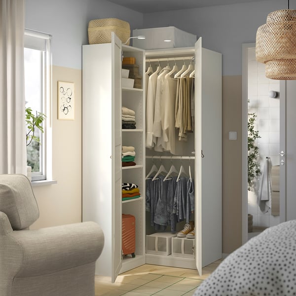 Geschlossener Kleiderschrank mit offenem linken Bereich, der Hemden, gefaltete Kleidung und Aufbewahrungsboxen zeigt.