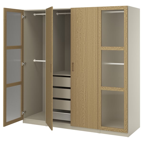 Ein offener Holzschrank namens PAX mit Regalen und Kleiderbügeln. Es ist in hellbrauner Eiche lackiert und verfügt über Schubladen und Glastüren.