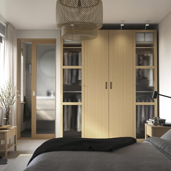 Modernes Schlafzimmer mit PAX-Kleiderschrank und Glasscheiben.