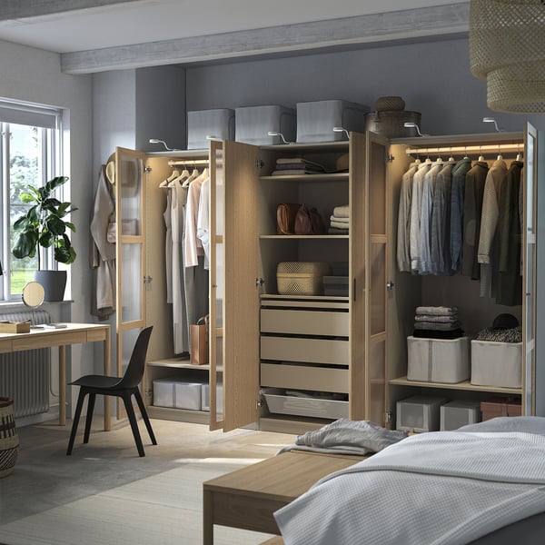 Organisierter begehbarer Kleiderschrank mit Kleiderbügeln, Regalen, Schubladen und Aufbewahrungsbehältern. Eingebaute Beleuchtung und verstellbare Füße.
