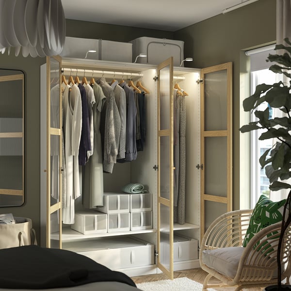 Moderner offener Kleiderschrank mit Kleidung, durchsichtigen Türen, Licht und Aufbewahrungsboxen.