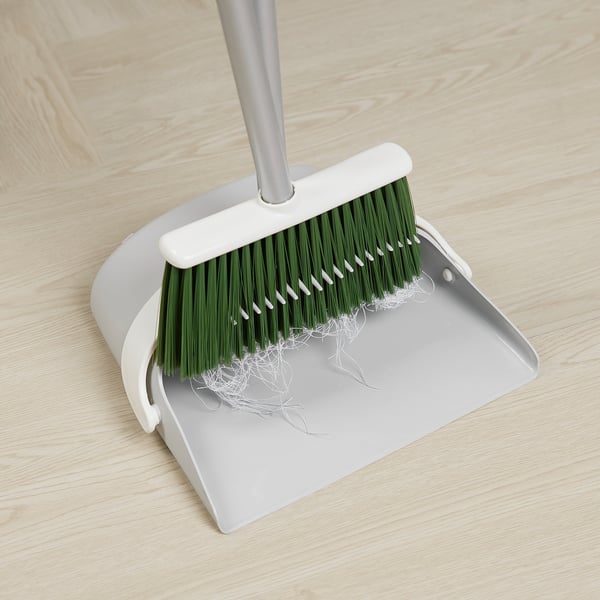 Ein Set aus Kehrschaufel und Bürste mit faltbarem Design und Gummirand für eine effiziente Reinigung.