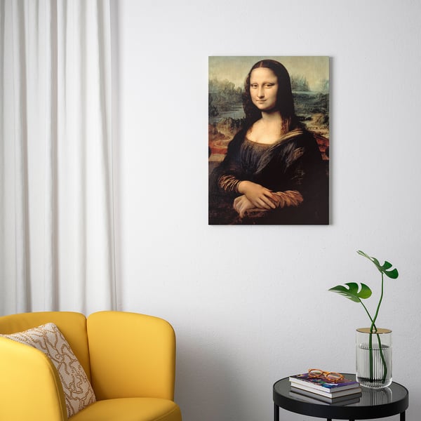 Minimalistisches Zimmer mit gelbem PJÄTTERYD-Stuhl, Leonardo-da-Vinci-Porträt und kleinem Tisch mit Büchern und Pflanzen.