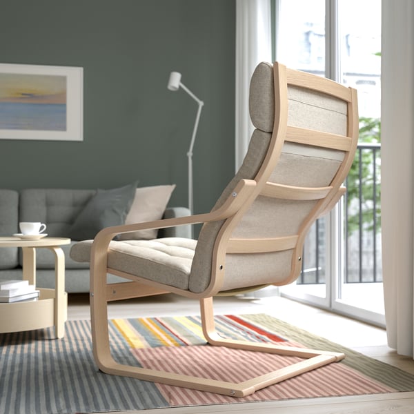 Modernes Wohnzimmer mit POÄNG Sessel, Stadtblick und grauem Sofa.