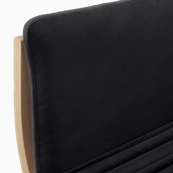 Schwarzer gepolsterter Stuhl mit Holzgestell, der sich durch hochwertige Materialien und komfortables Design auszeichnet.