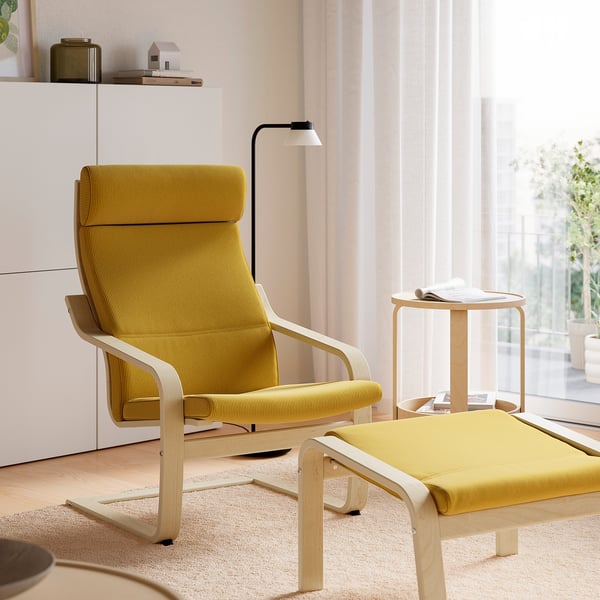 Gelber POÄNG-Stuhl und Ottoman im gemütlichen Wohnzimmer mit natürlichem Licht.