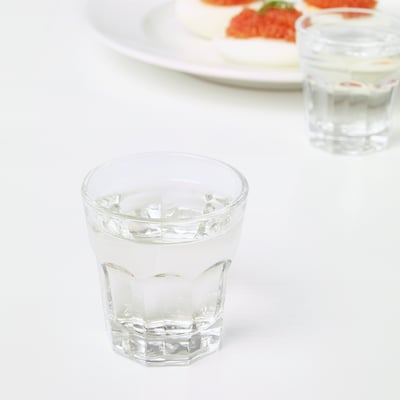 Zwei Gläser mit Eis stehen auf einem weißen Tisch, daneben ein Teller mit Essen.