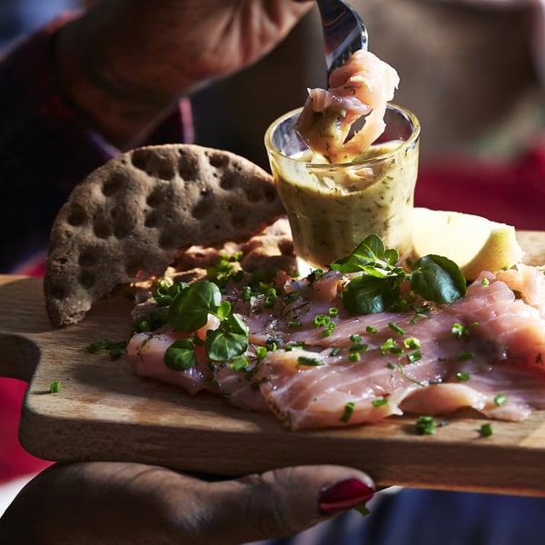 In der Hand mit geräuchertem Fisch, Gemüse, Brot und Dip-Sauce.