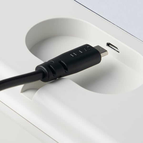 Schwarzes USB-Kabel, das mit weißer Ladeschale für PRAKTSPIREA Akkulampen verbunden ist.