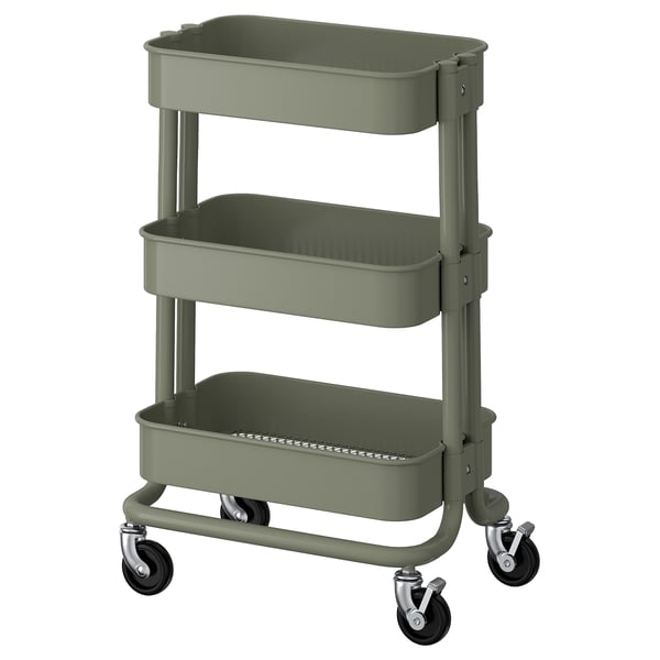 Ein grüner dreistöckiger Lagerwagen von ikea RÅSKOG auf Rädern, der für kompakte Räume konzipiert ist.