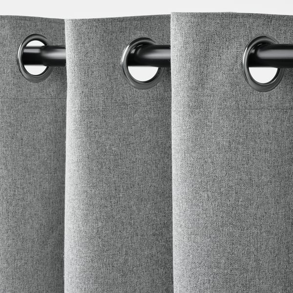 Nahaufnahme von grauen Vorhängen mit Metallösen, die die Block-Out-Funktionalität zeigen.