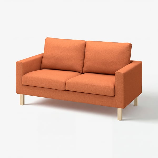 Ein leuchtend orangefarbenes modernes Sofa mit Holzbeinen, gemütlichen Kissen, Mid-Century-Design.