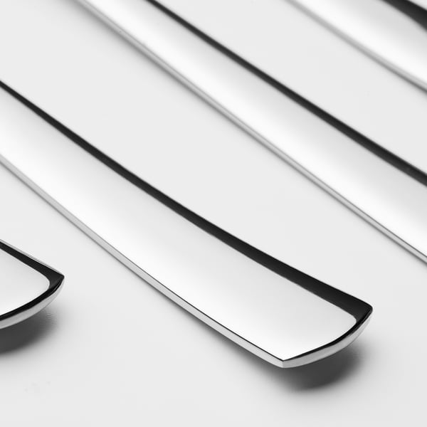 Polierte Metalllöffel, die ordentlich angeordnet sind, Licht reflektieren und ein schlankes Design und Langlebigkeit aufweisen.