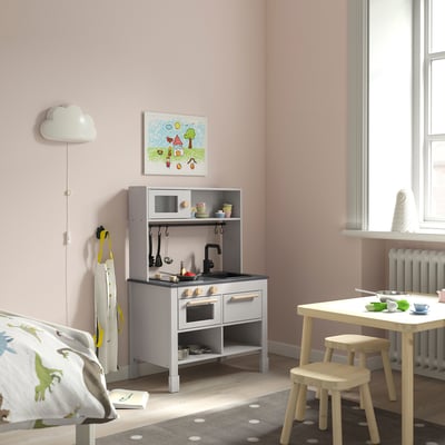 Kinder graues Spielküchenset, Wand, Fenster, Dinosaurierkissen.
