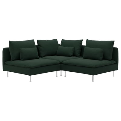 Dunkelgrünes, modernes Ecksofa mit zahlreichen Kissen, erhöht auf schlanken Chrombeinen.