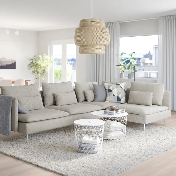 Modernes Wohnzimmer mit großem weißem SÖDERHAMN-Sofa, elegantem Couchtisch, stilvoller Pendelleuchte und Stadtblick.