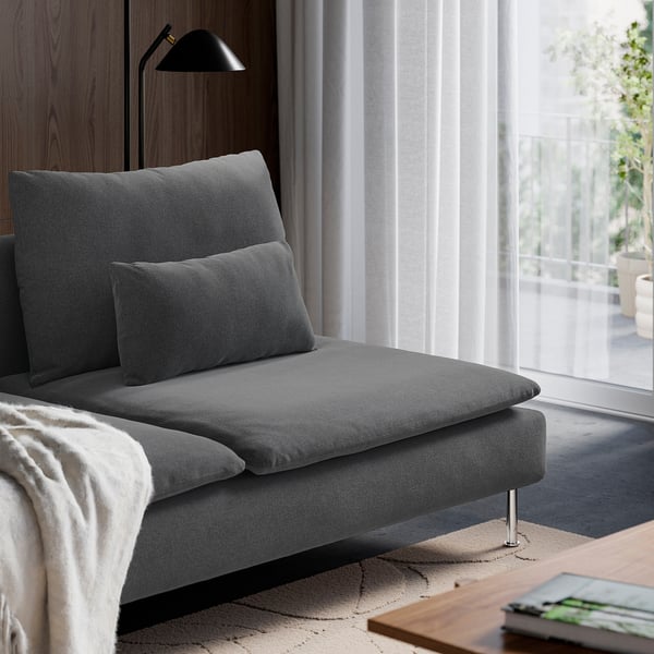Moderne graue Chaiselongue mit Kissen neben dem großen Fenster, die Entspannung und Komfort bieten.