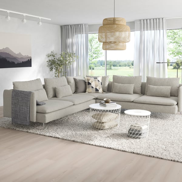 Modernes Wohnzimmer mit großem grauem SÖDERHAMN-Sofa, weißem Couchtisch und großen Fenstern. Sanfte Beleuchtung, gemütliche Kissen und minimalistisches Dekor.