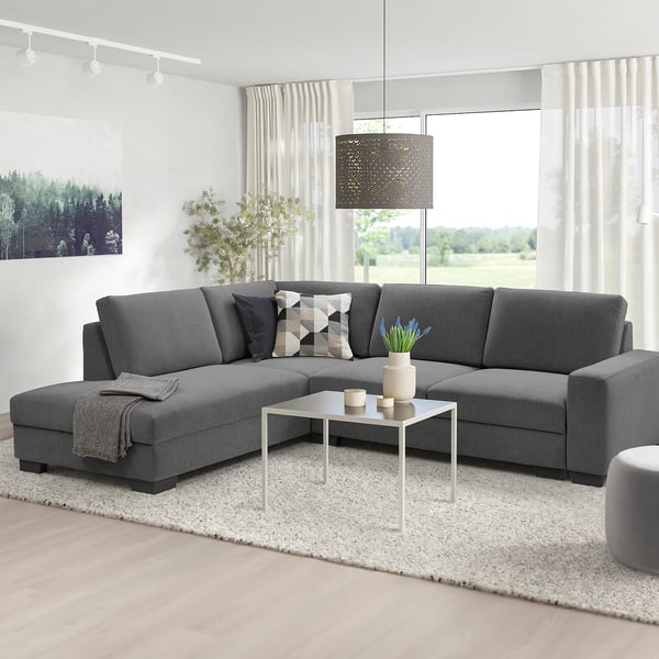 Graues Sektionssofa mit weichen Kissen im gemütlichen Wohnzimmer.