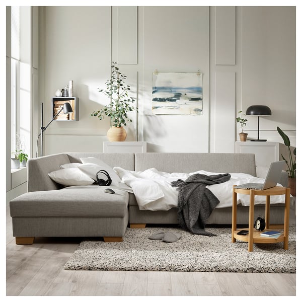 Graues Sofa, weißer Teppich, Beistelltisch, Lampe, Pflanzen, Kunst, Kopfhörer, gemütliches Zuhause.