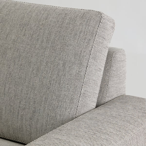 Nahaufnahme einer modernen Couch, SÖRVALLEN, in neutralen Tönen. Strukturierter Stoff und abgewinkelte Rückenlehne sichtbar.