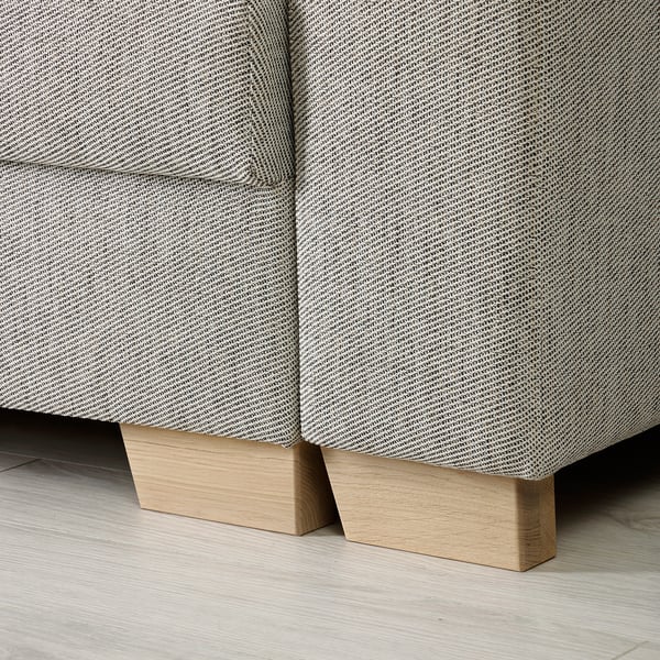 Detail des Sofagestells: zwei Holzteile mit heller Oberfläche, die den schlanken, gemusterten Stoff der Sofas nahtlos unterstützen.