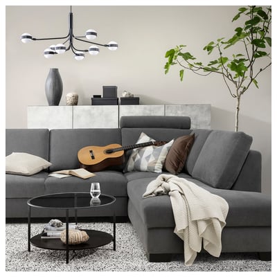 Modernes graues L-förmiges Sofa mit Kissen, Decke, Gitarre, Büchern, Glas, Pflanzen und trendigen Dekorationen.