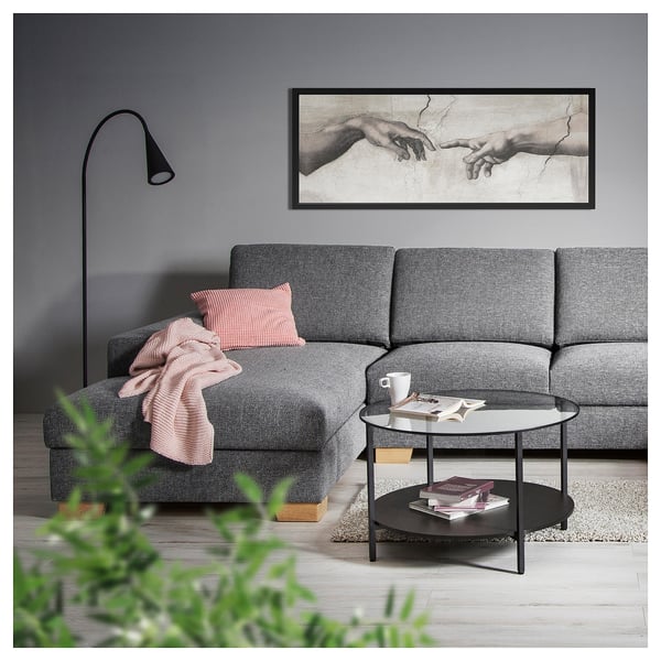 Modernes Wohnzimmer mit SÖRVALLEN Sofa, Wurfdecke, gestreiftem Kissen, Couchtisch, Kunstwerk, Lampe und Pflanzen.