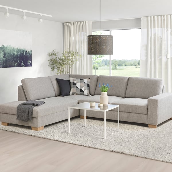 SÖRVALLEN Sektionssofa, hellgrau, modernes skandinavisches Design. L-Form, fester Sitz, abgewinkelte Rückenlehne. Heller Raum mit Pflanzen und weißem Couchtisch.