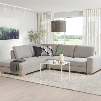 SÖRVALLEN Sektionssofa, hellgrau, modernes skandinavisches Design. L-Form, fester Sitz, abgewinkelte Rückenlehne. Heller Raum mit Pflanzen und weißem Couchtisch.