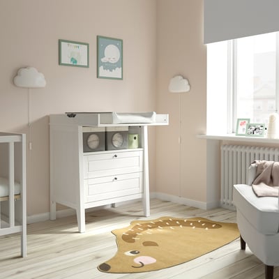 Babyzimmer mit SUNDVIK-Kommode, Teppich, Lampen und Kinderbett.