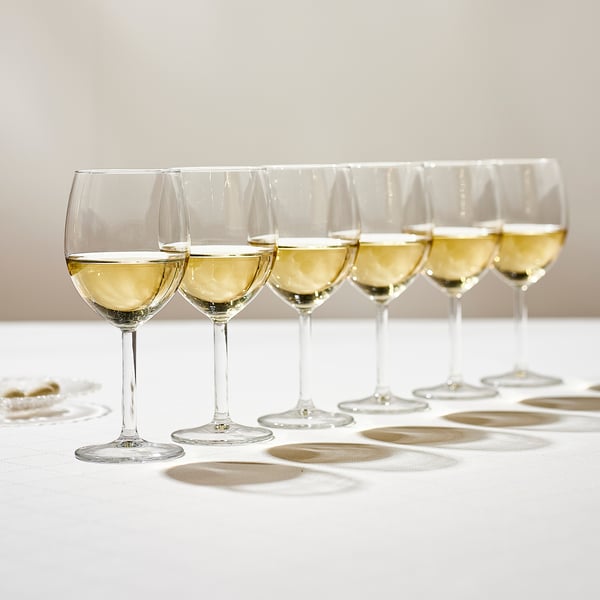 Sechs Weingläser, jedes mit Weißwein gefüllt, ordentlich auf einer weißen Tischdecke aufgereiht und verstärken die Aromen und Geschmacksrichtungen des Weins.