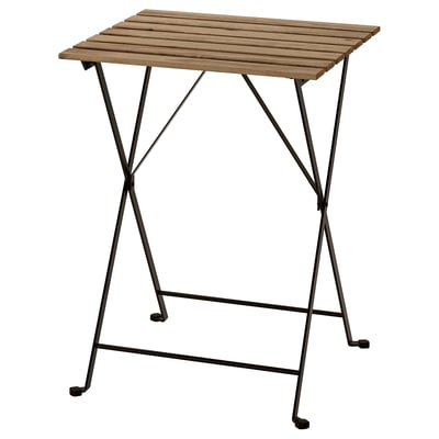 Ein TÄRNÖ Outdoor-Tisch mit Holzplatte und schwarzen Metallbeinen, faltbares Design.