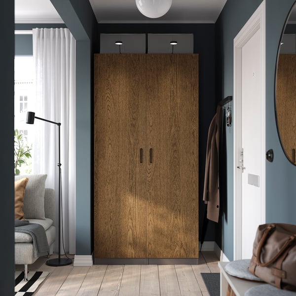 TONSTAD Kleiderschrank in stilvollem Schlafzimmer mit grauem Stuhl, Lampe und Spiegel.