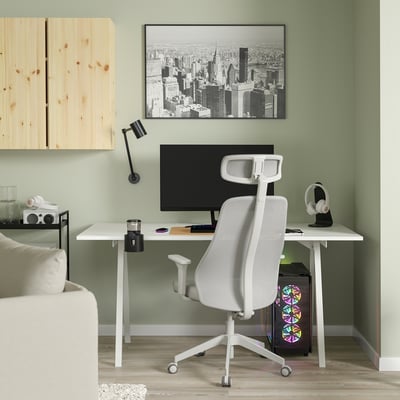 Stilvolles Homeoffice mit TROTTEN Stuhl, Schreibtisch, Regalen und grüner Wand. Modernes Dekor mit Stadtbildkunst und schwarzer Lampe.