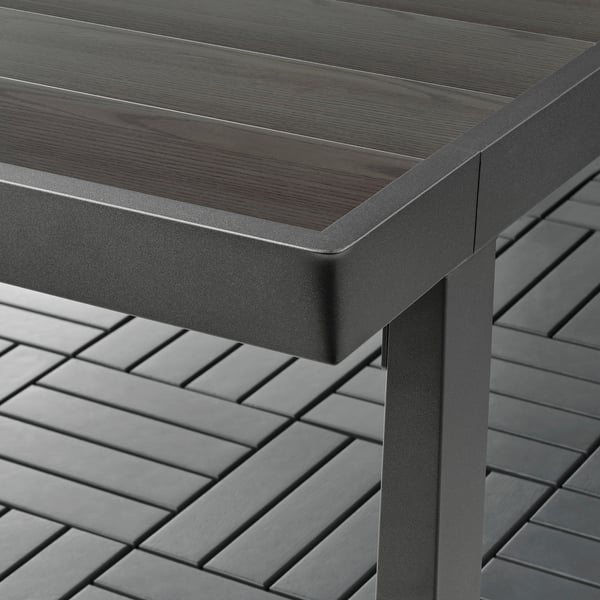 Moderner, langlebiger Outdoor-Tisch mit eleganter Metalloberfläche, robustem Gestell und sauberer holzähnlicher Oberfläche.