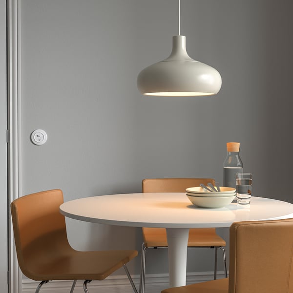 Moderner Essbereich mit VÄXJÖ-Lampe, Tisch, orangefarbenen Stühlen, Schalen und Gläsern.