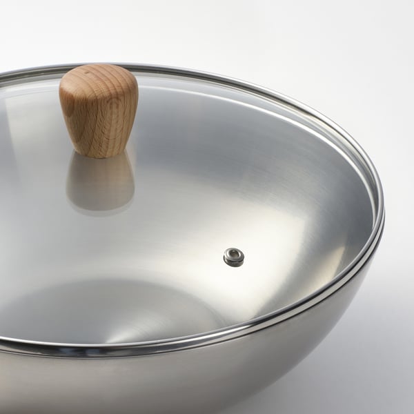Ein hochwertiger Edelstahl-Wok mit glatter, reflektierender Oberfläche und stabilem Holzgriff, ideal zum Kochen.