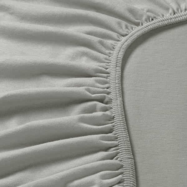 Nahaufnahme eines weichen, weißen Jersey-Baumwolltuchs mit komplizierten, elastischen Kanten für einen sicheren Sitz.