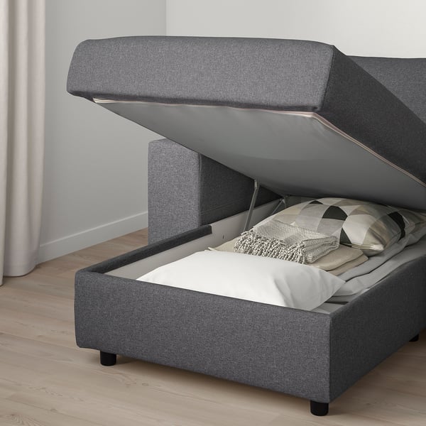 Graues Stoffschlafsofa mit Stauraum und dicker Matratze, offen zur Aufbewahrung.