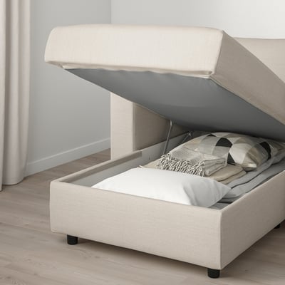 Ein cremefarbenes VIMLE-Sofa mit Stauraum. Die Chaiselongue hat einen offenen Deckel, der den Blick auf die Kissen im Inneren freigibt.
