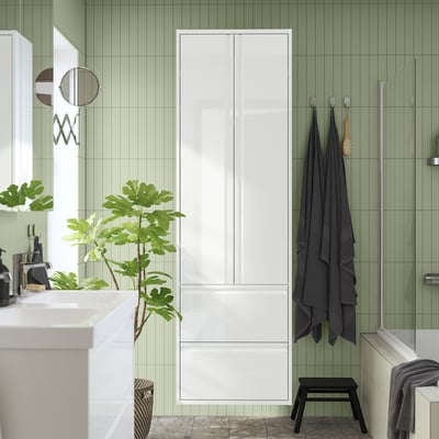 Modern bathroom with ÄNGSJÖN white cabinet, sleek design, green tiles, and ample storage.