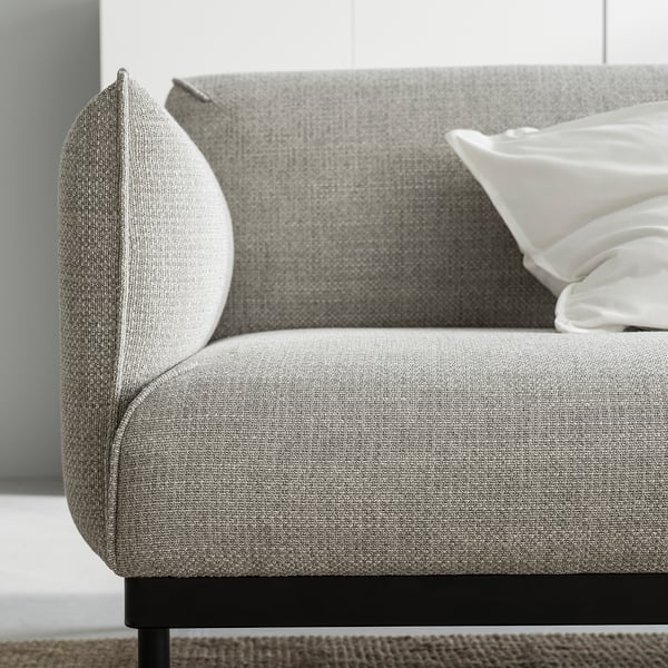 Modern grey fabric sofa, sleek metal legs, white pillows.